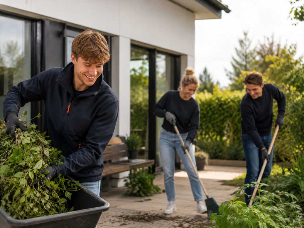 Werkers snoeien en vegen in een tuin